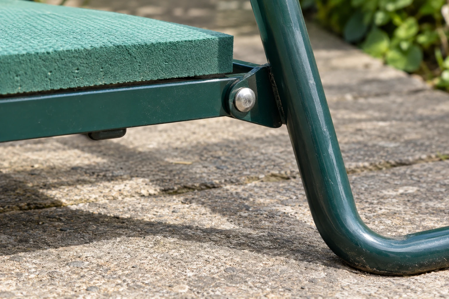 A folding garden kneeler frame hinge and leg on level paving